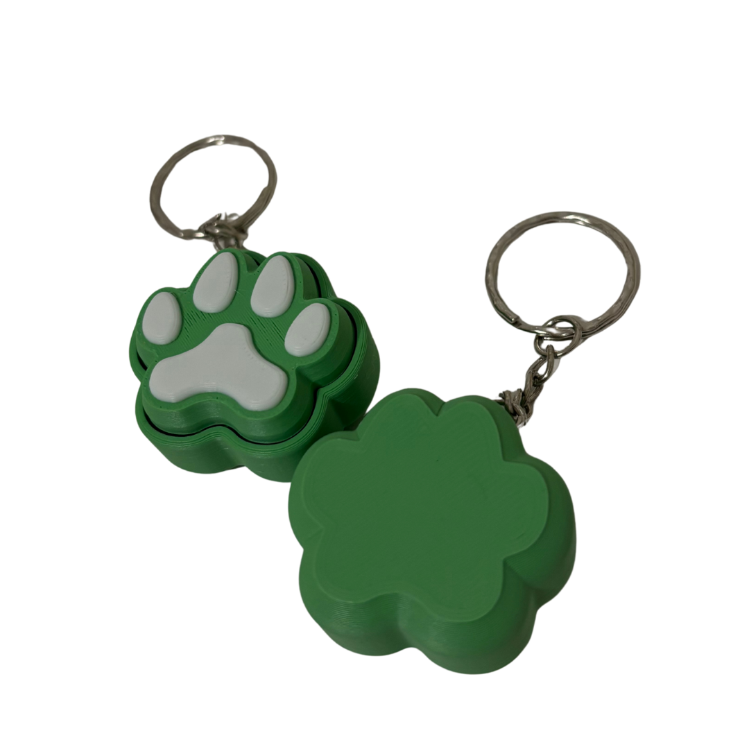 Green keychain with a paw print design on a white background