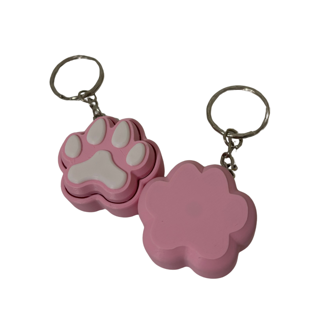 Pink paw-shaped keychain with a white interior on a white background