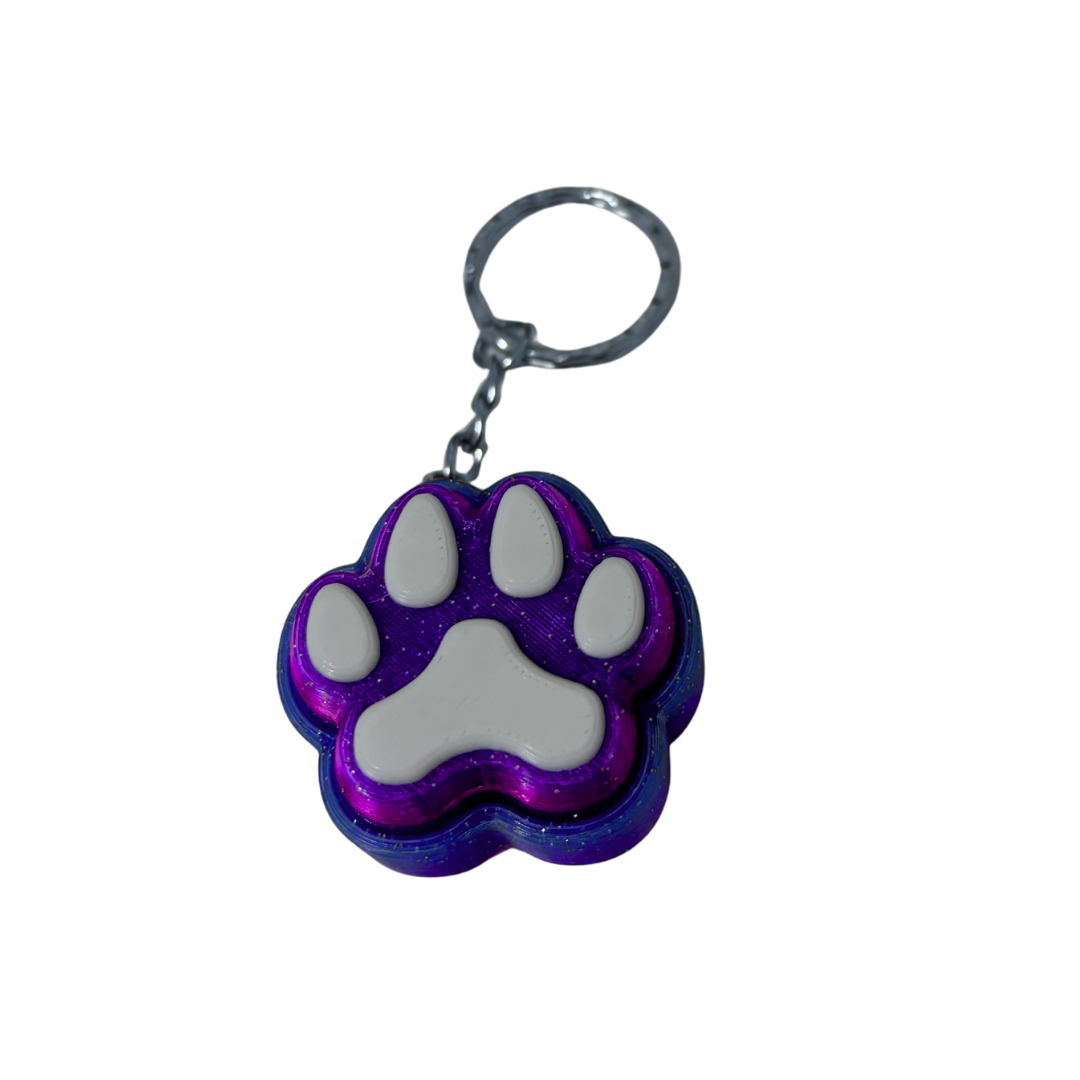 Keychain with a purple and gray paw print design on a white background
