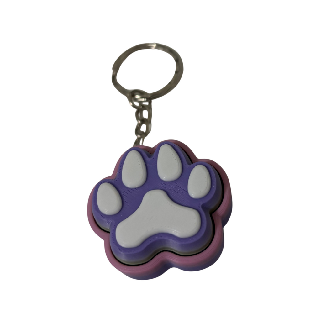 Keychain with a purple and green pink paw print design on a white background