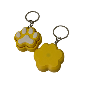 Two yellow keychains with paw print designs on a white background