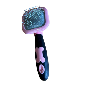 Pet grooming brush with pink top and black handle featuring a bone design on a white background