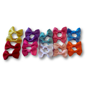 Row of colorful hair bows on a white background