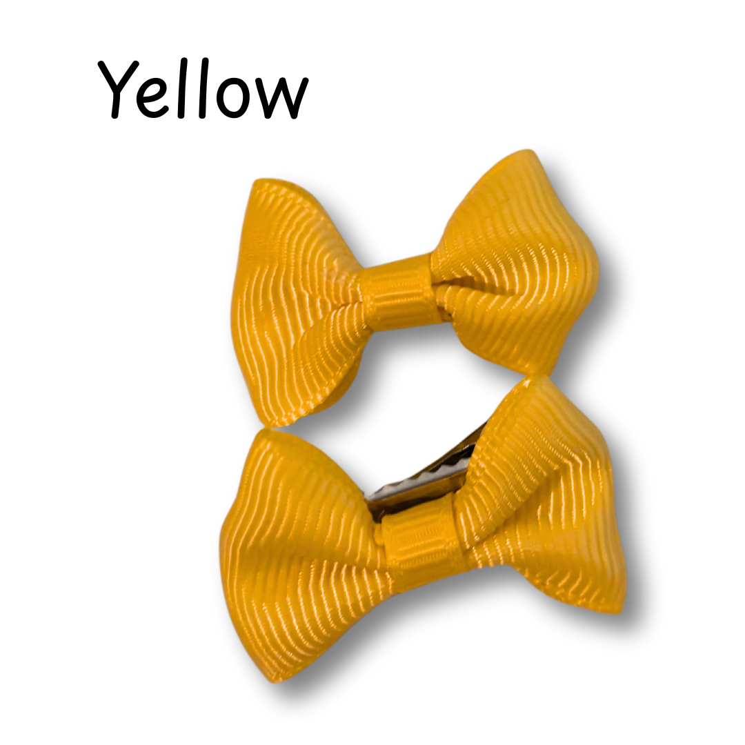 Yellow hair bow with a clip on a white background