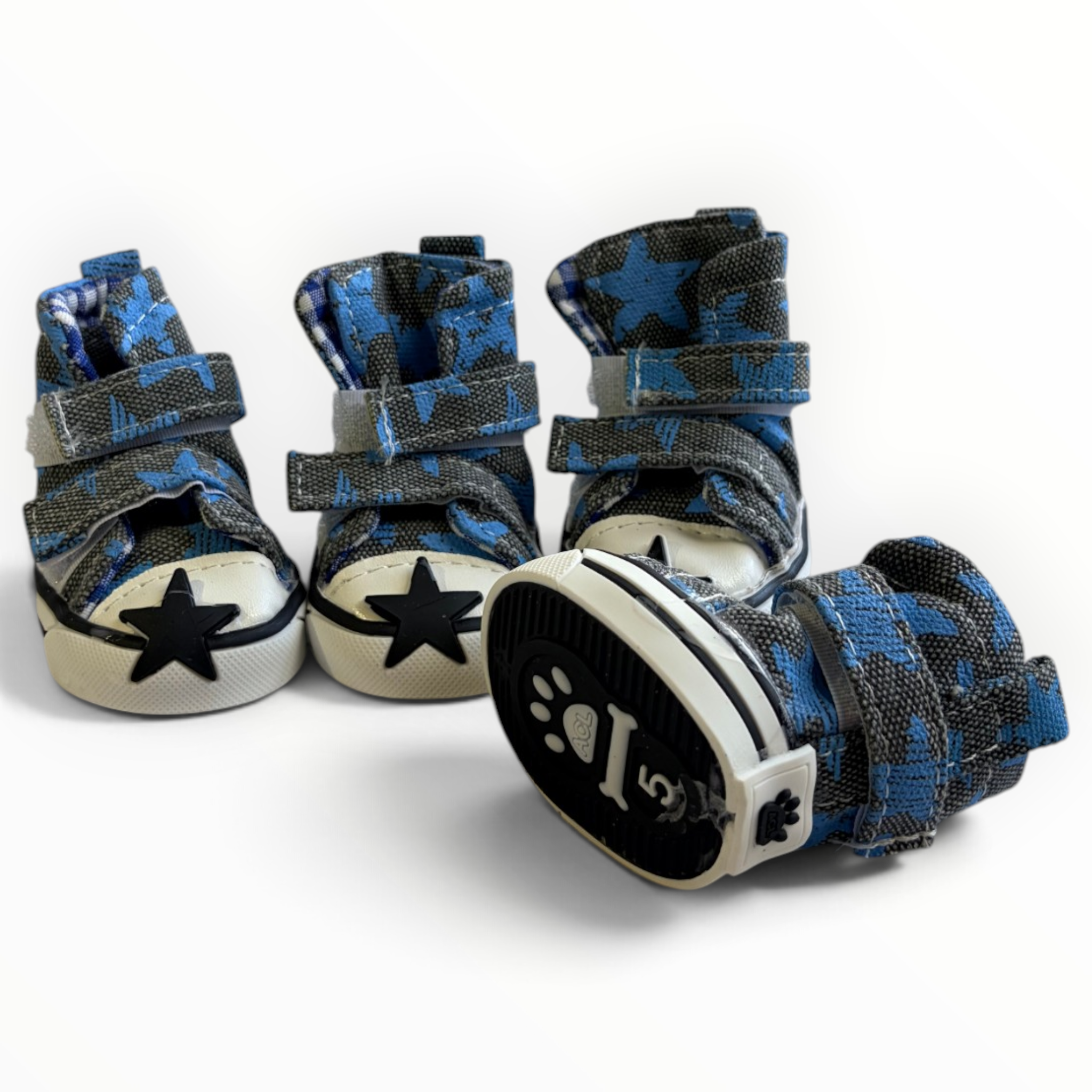 Three blue and black patterned pet boots with white soles and black star details, arranged on a clean white background.