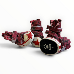 A pair of dog boots with a red and black plaid fabric upper, featuring white and red star details on the toes and a black paw print sole with the number 5.