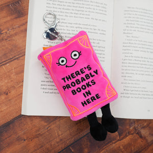 Pink plush book with a face and text 'There's probably books in here' on an open book.