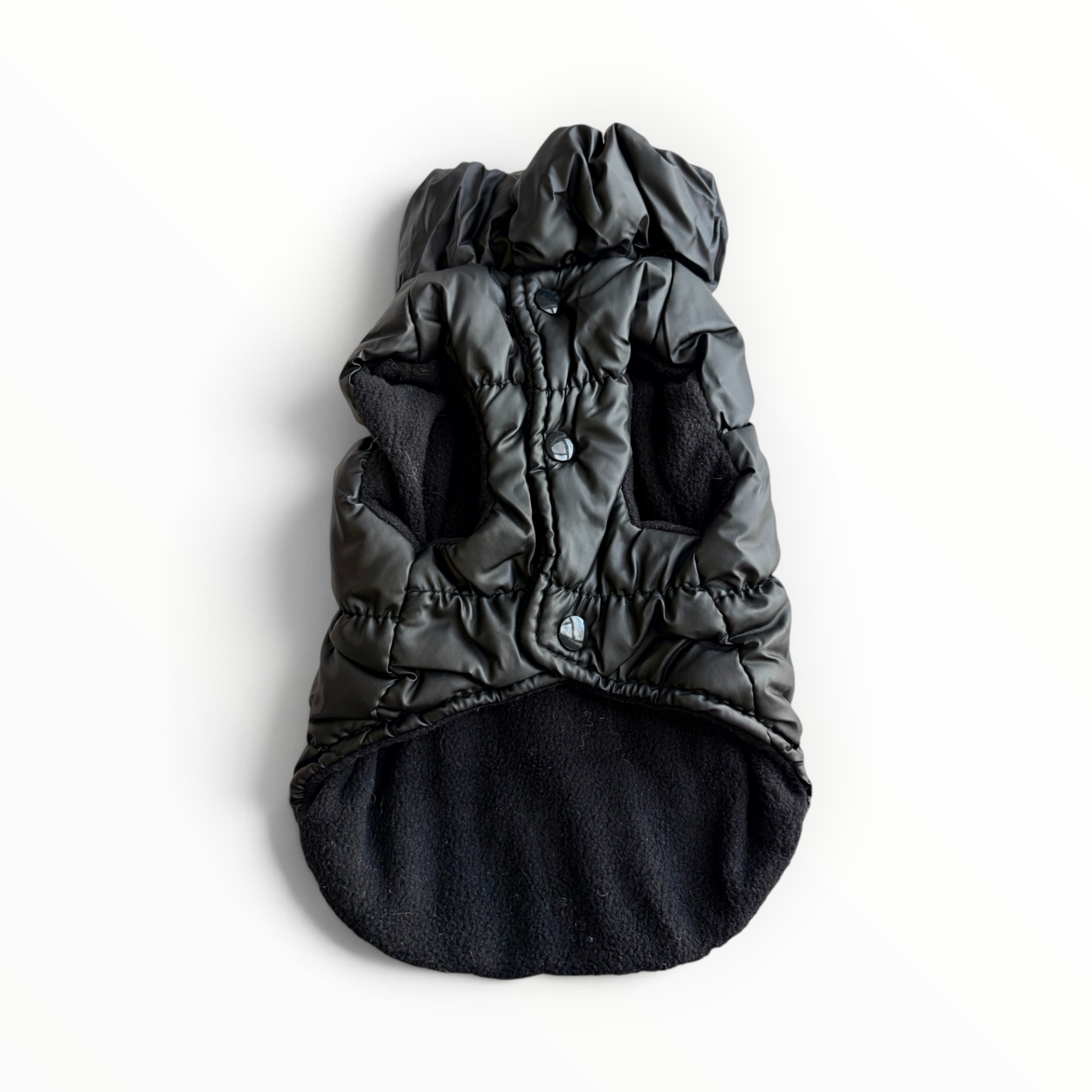 A black puffer-style pet coat with a hood and soft fleece lining, laid flat on a white background.