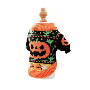 A small knit pet sweater with a Halloween jack-o'-lantern design, displayed on a wooden mannequin torso against a plain white background.