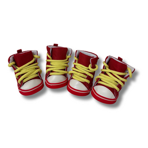 Four red shoes with yellow laces on a white background