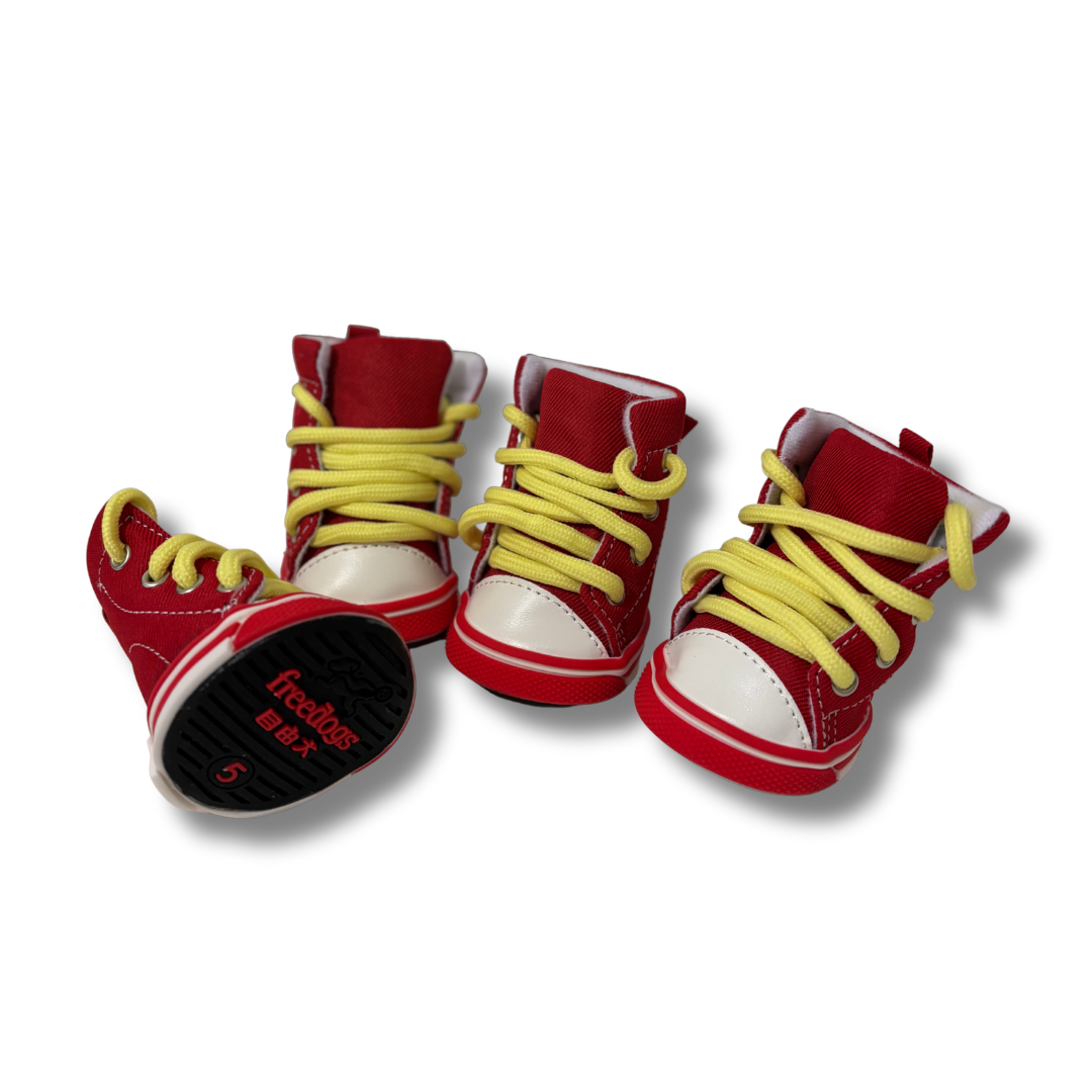 Red and white baby shoes with yellow laces on a white background