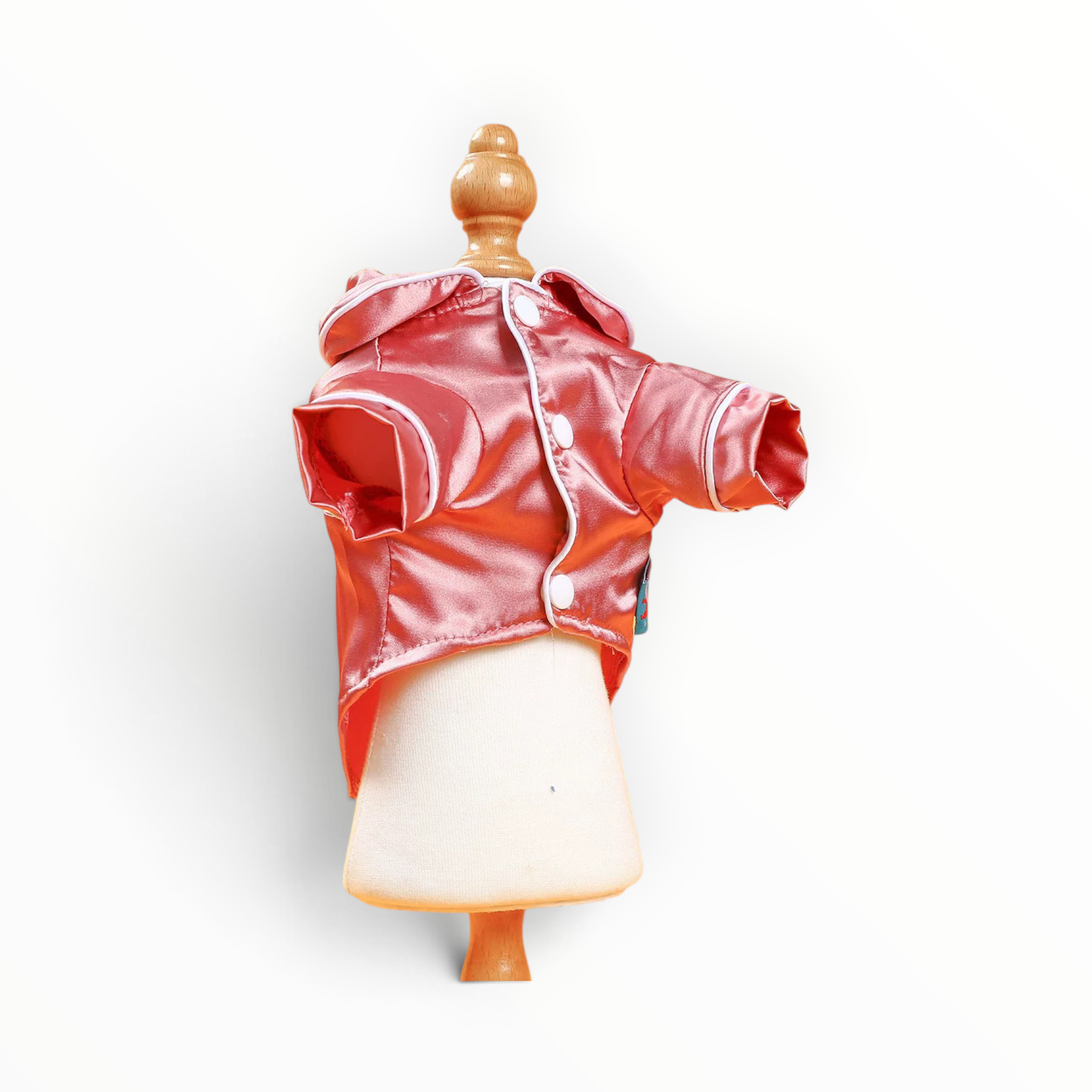 A shiny coral-pink hooded jacket displayed on a small cream-colored mannequin torso with a wooden neck cap, set against a plain white background.