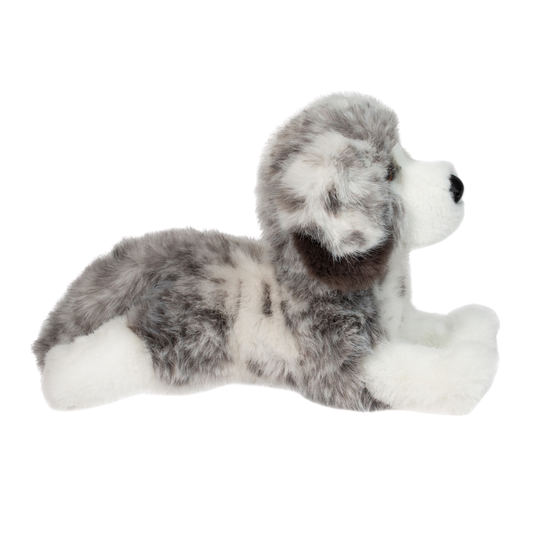 Plush toy dog lying on a white background