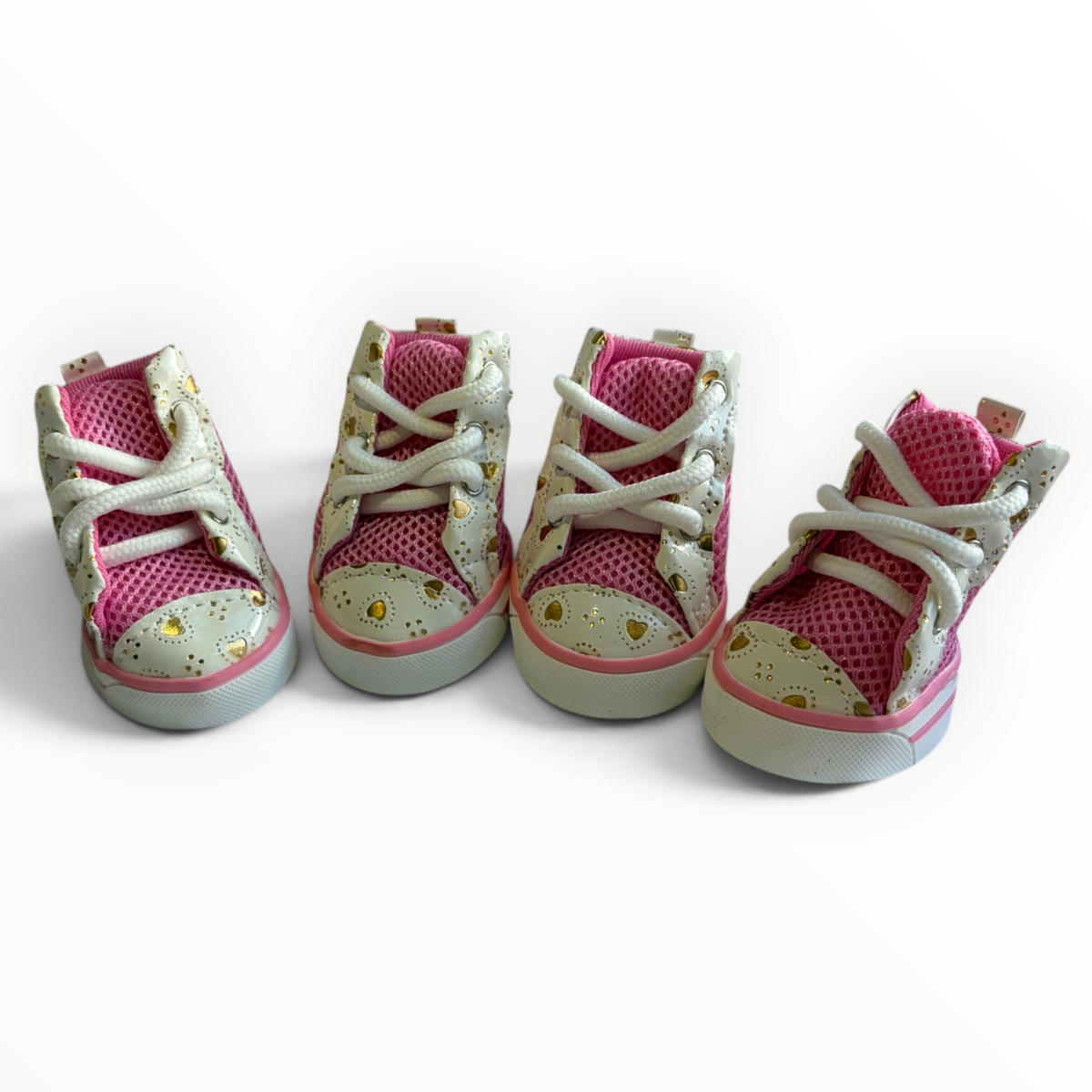 Four toddler high-top sneakers arranged in a row on a plain white background. The shoes feature a bright pink mesh upper, white laces, a light beige toe cap with a gold floral pattern, and a light gray sole.