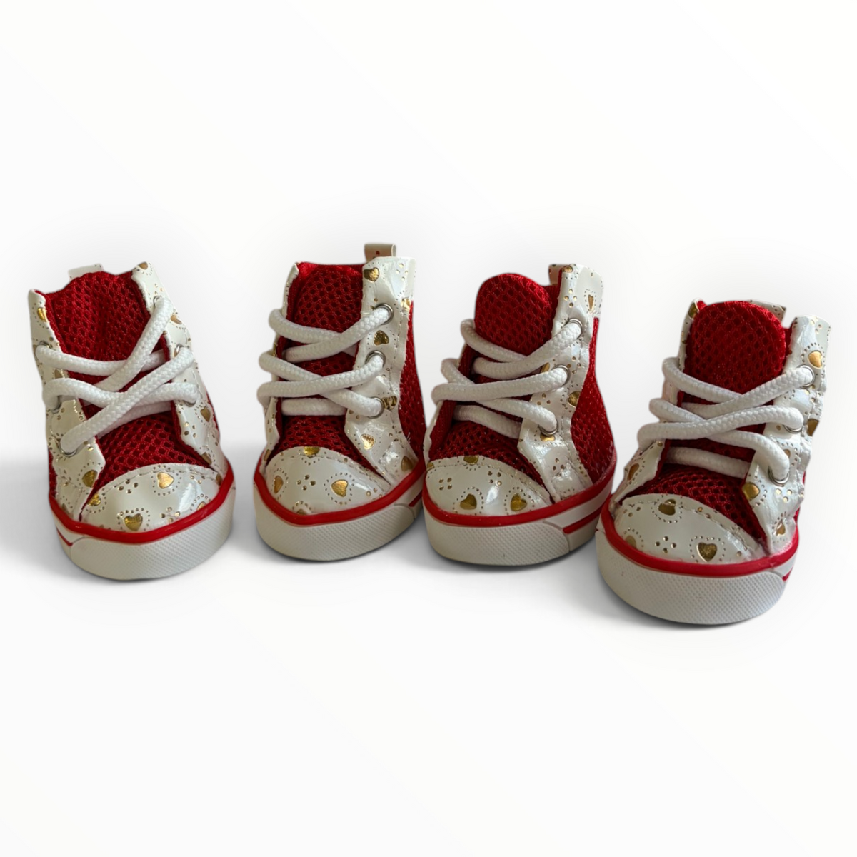 Four miniature high-top baby shoes in red and white with gold heart details, arranged on a plain white background.