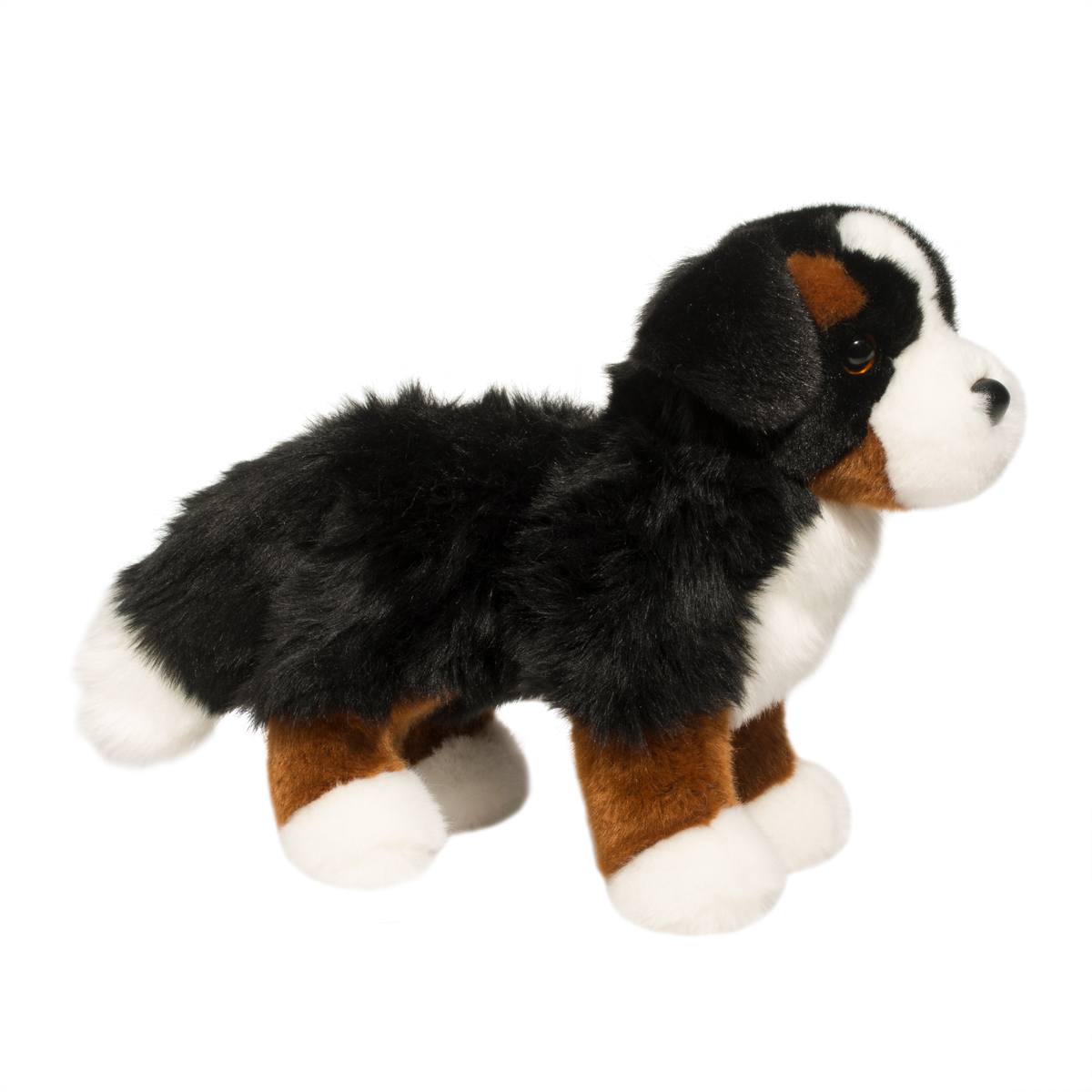 Plush toy dog with black, brown, and white fur on a white background