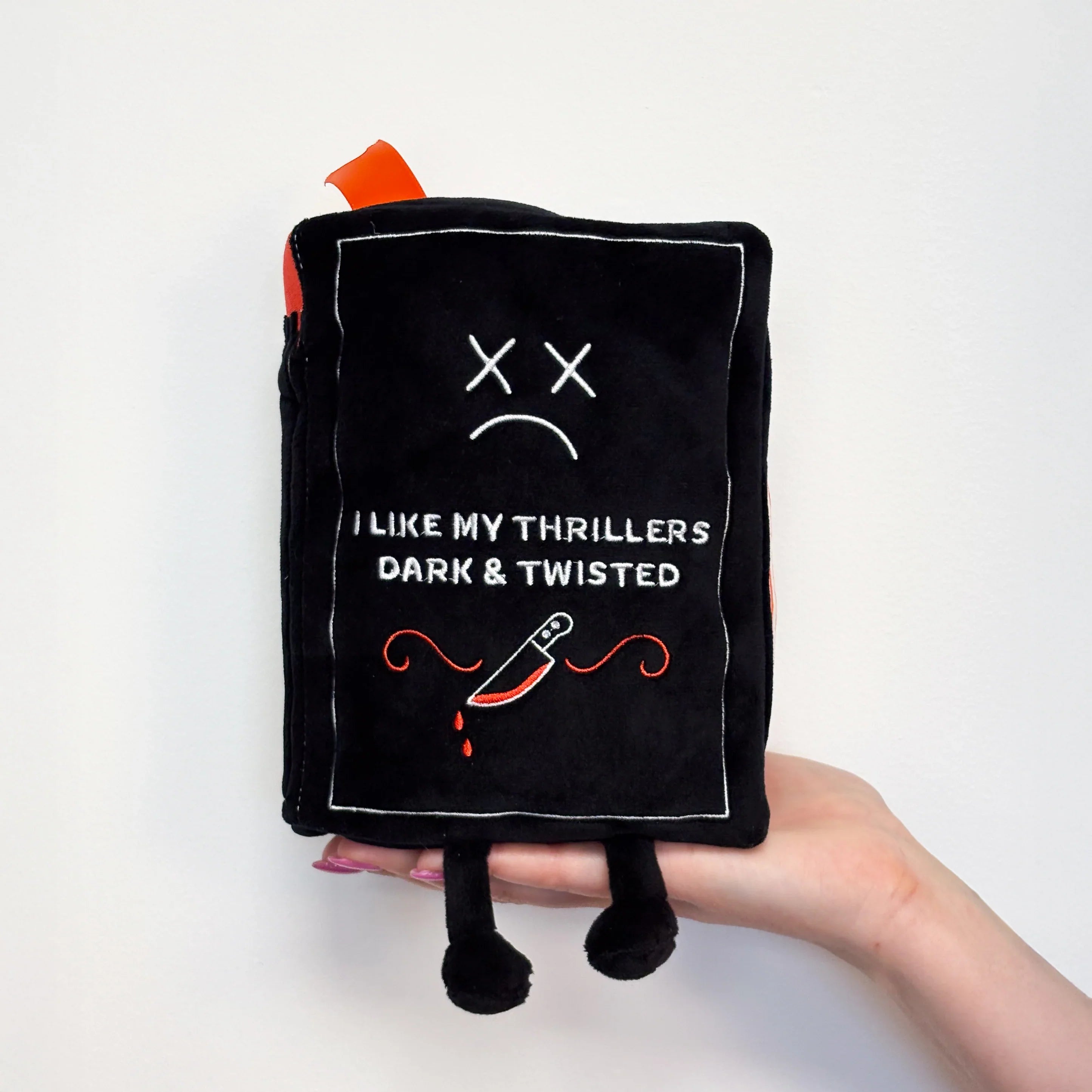 Black plush toy with text and design on a white background