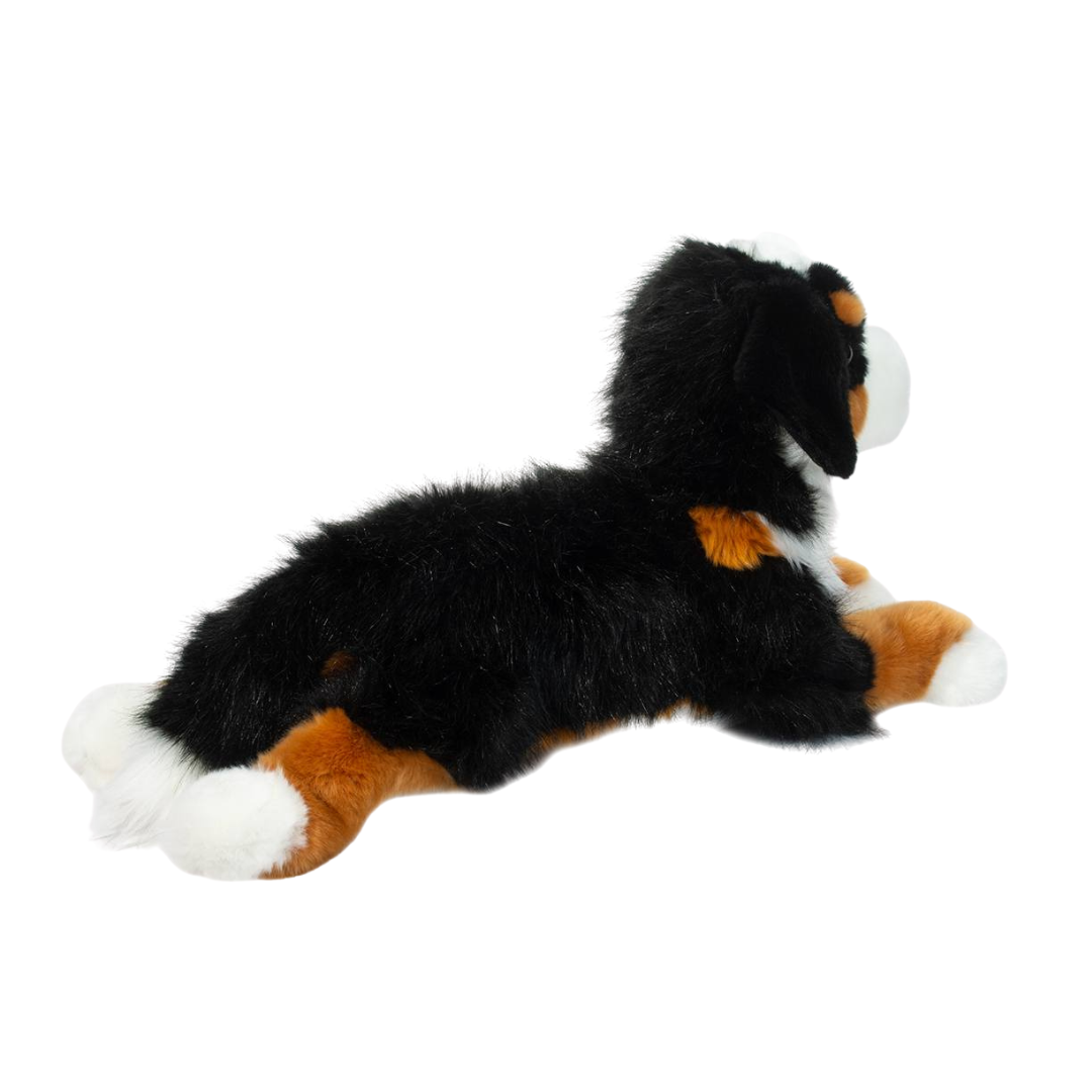Plush toy dog with black, brown, and white fur on a white background