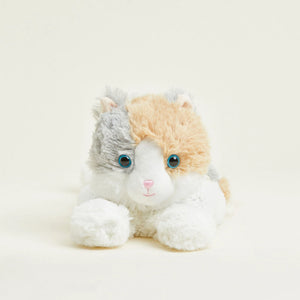 A plush toy cat with a tri-color fur pattern of white, light orange, and light gray, featuring large blue eyes and a small pink stitched nose, lying down against a plain off-white background.