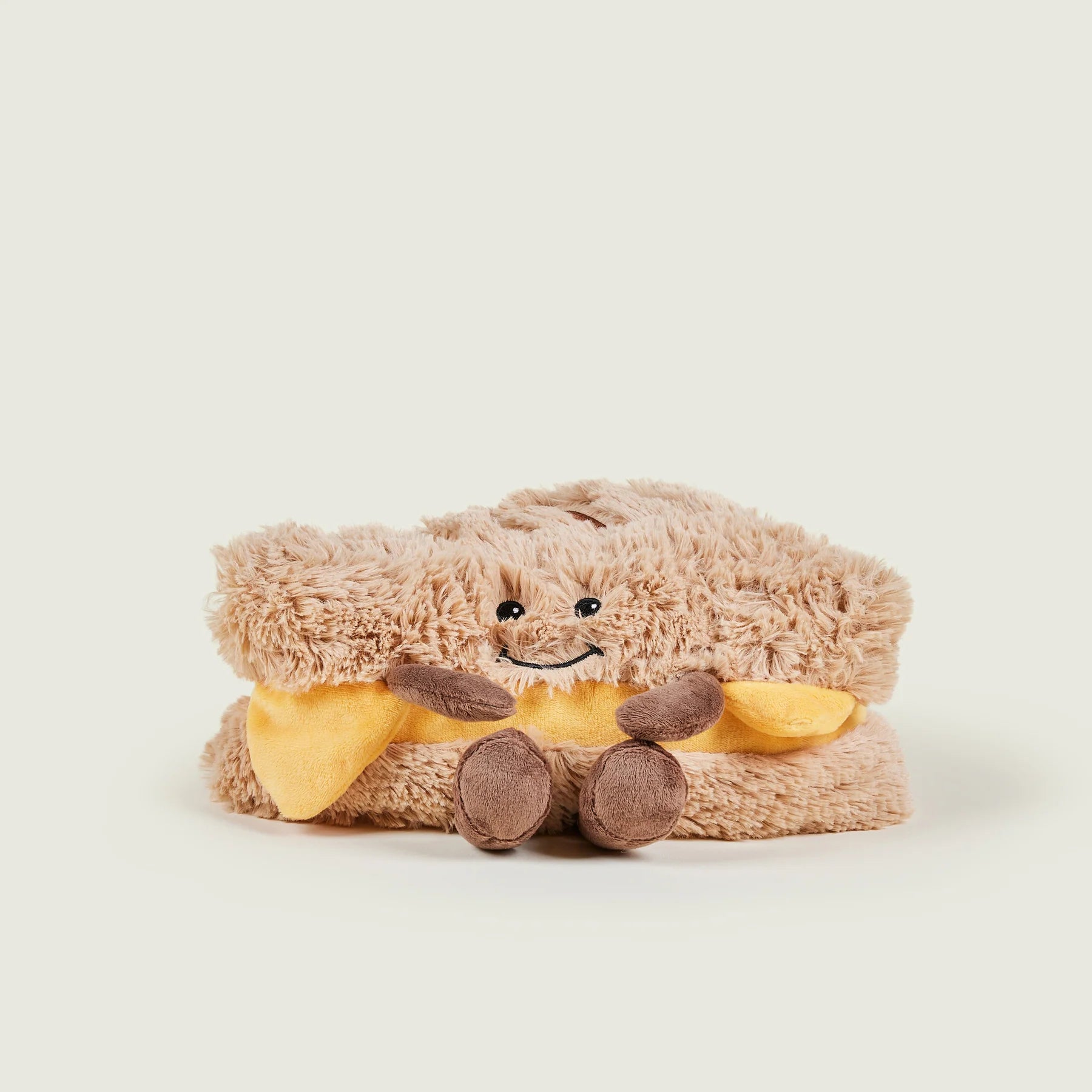 Plush toy resembling a sandwich with a face on a light background