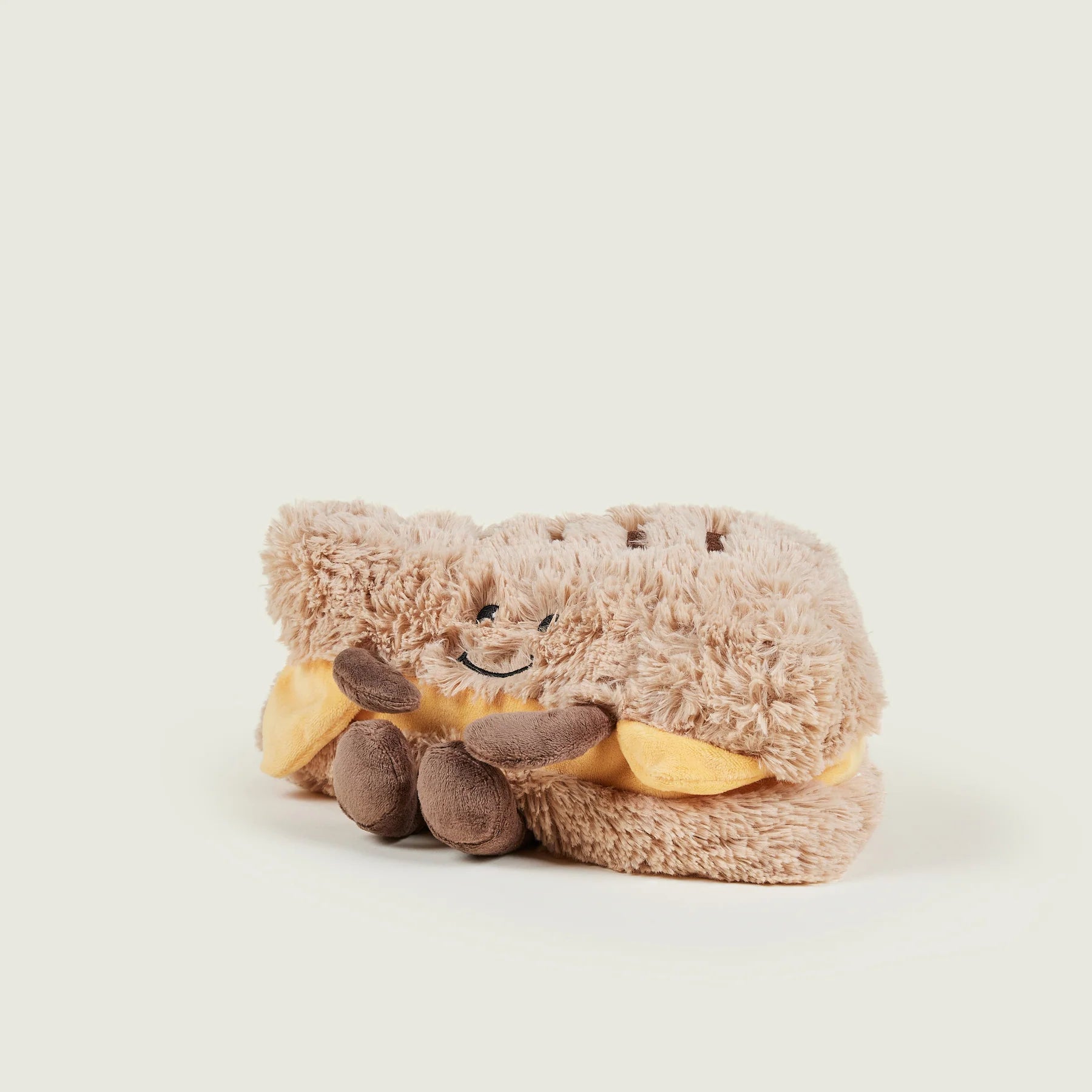 Plush toy resembling a dragon with a happy expression on a white background
