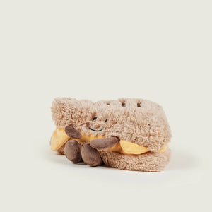 Plush toy resembling a dragon with a happy expression on a white background