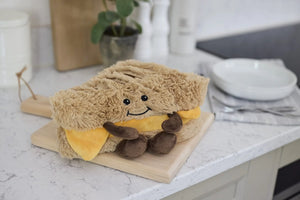 Plush toy resembling a sandwich on a kitchen counter