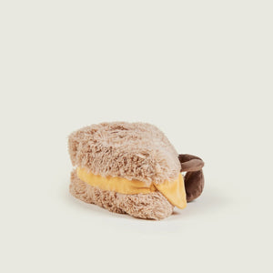 Plush toy resembling a bear with a yellow interior on a light beige background