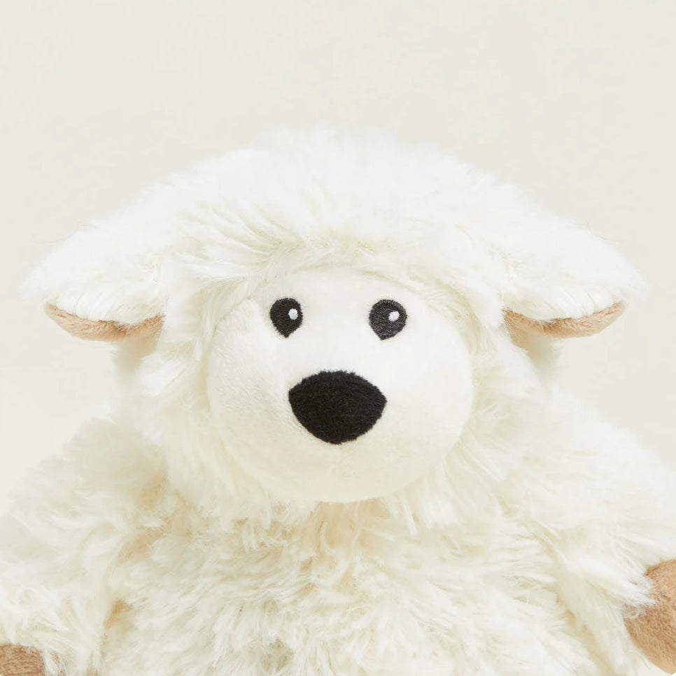 Plush toy resembling a white creature with black eyes and a black nose on a beige background
