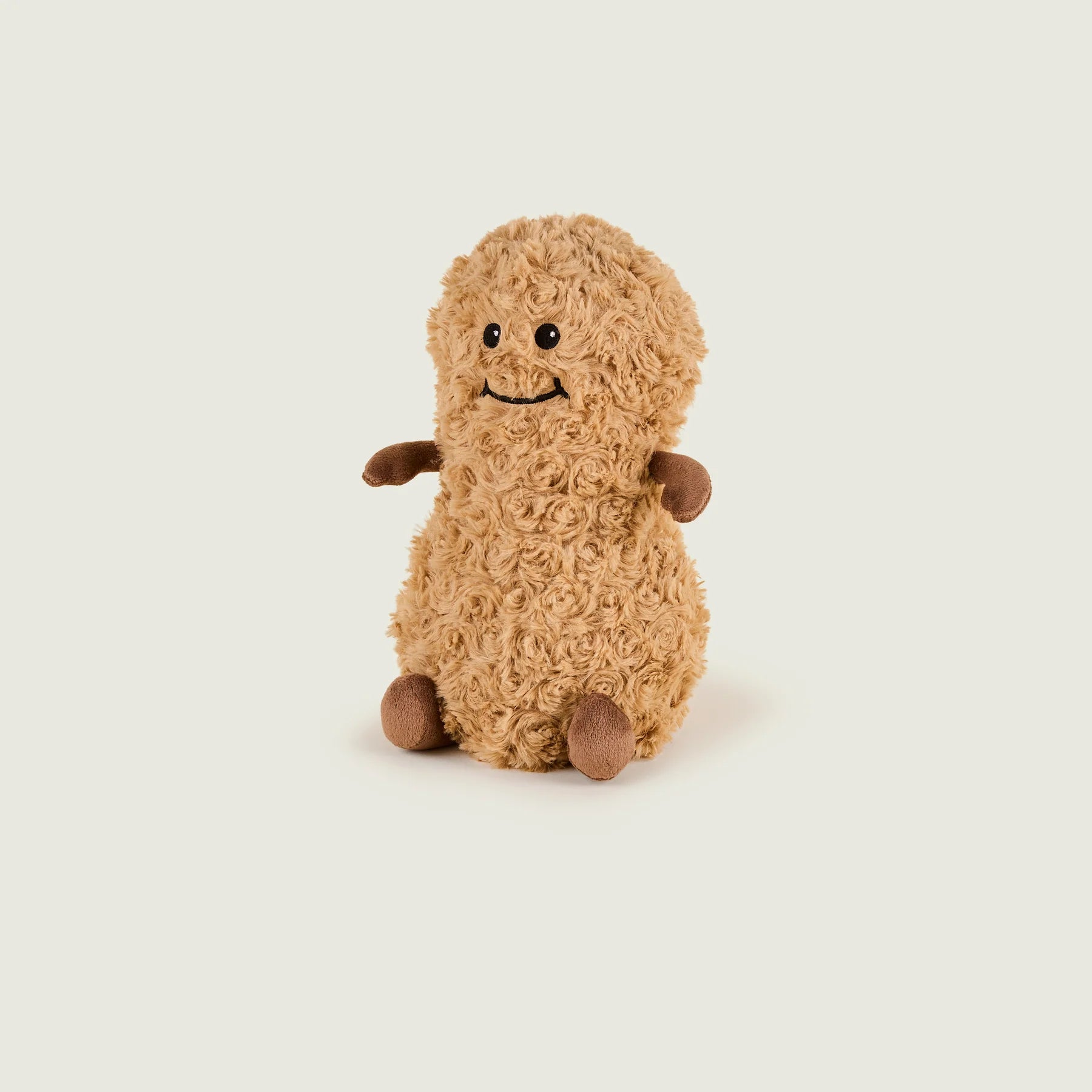 A small curly-textured plush toy in warm tan with darker brown feet and hands, shown centered on a plain light gray background.