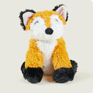 Plush toy fox with orange fur, white chest, and black paws on a light background