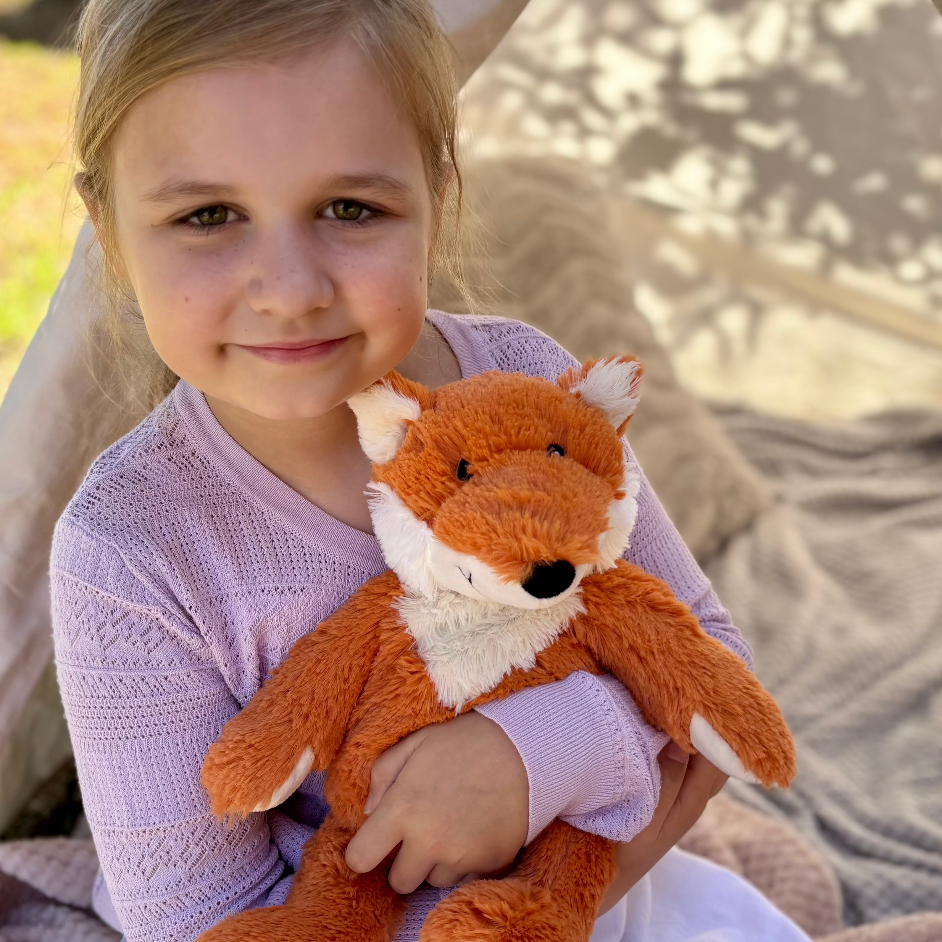 Girl holding Fox plushie - Warmies brand - weighted, lavender scented heat bag - emotional regulation tool
