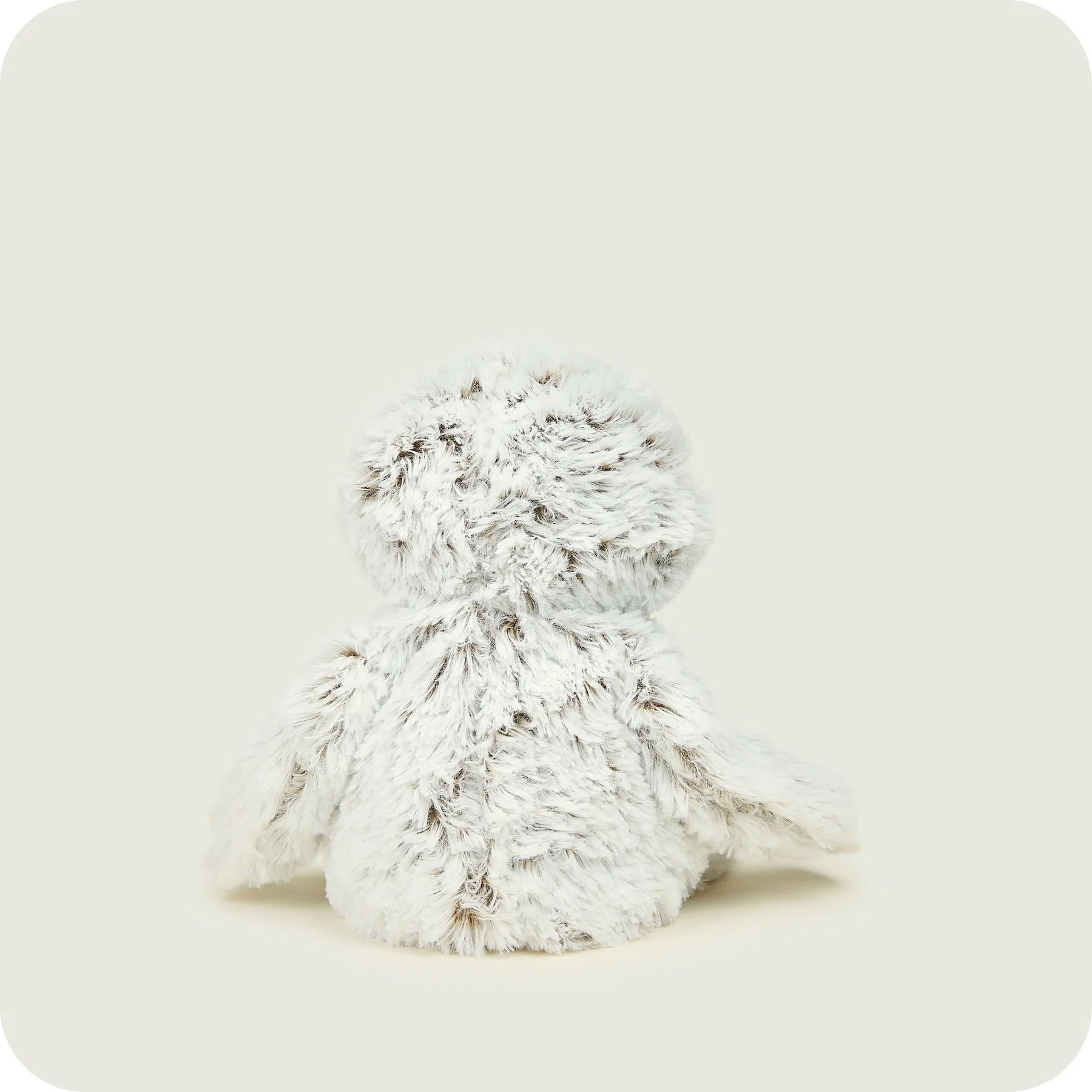 A fluffy white plush stuffed animal toy, shown from the back against a solid light beige background.