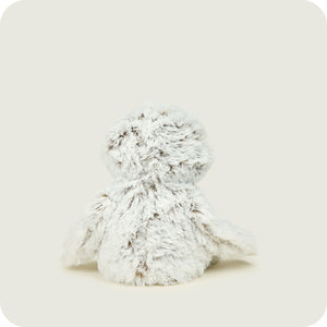 A fluffy white plush stuffed animal toy, shown from the back against a solid light beige background.