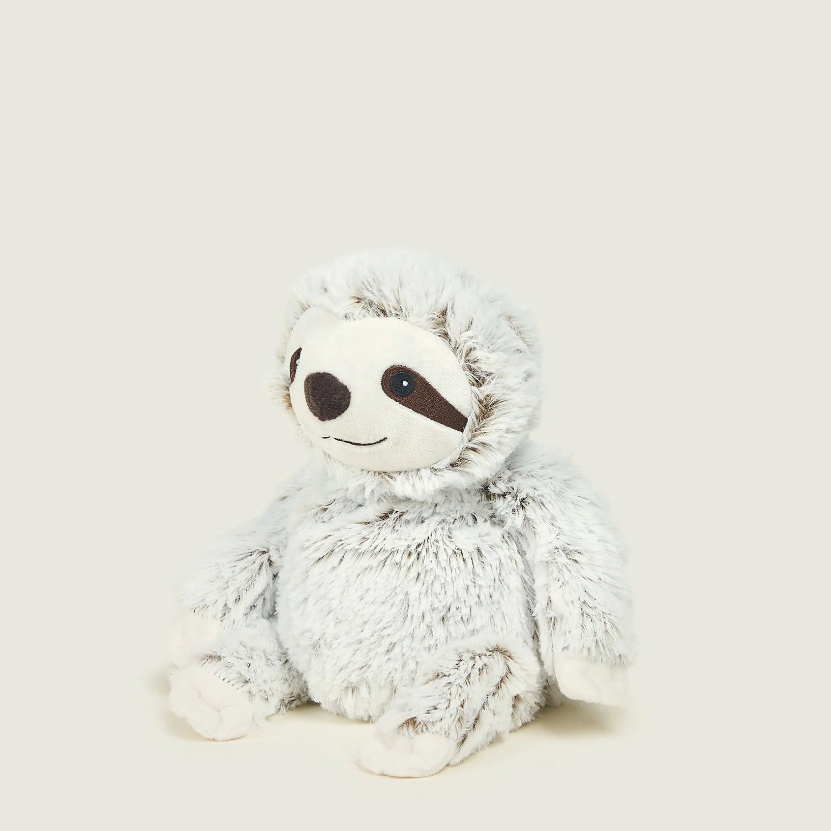 A plush sloth toy with fluffy light gray fur, a white face, and dark brown facial features, sitting against a solid light beige background.