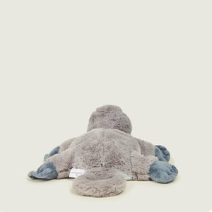 A plush toy shaped like a duck or crocodile, shown from the back on a plain light beige background.