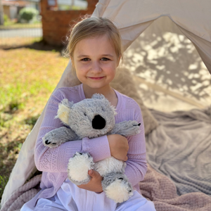 Girl holding Koala plushie - Warmies brand - weighted, lavender scented heat bag 