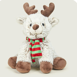 A plush stuffed reindeer toy with fluffy white fur, brown antlers, brown hooves, and a red and green striped scarf, sitting against a light beige background.