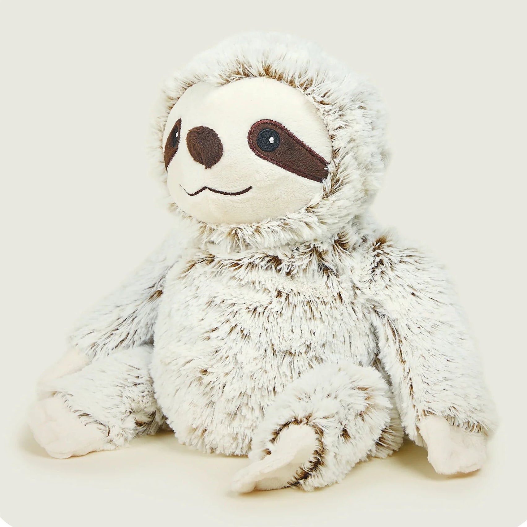 Plush toy sloth on a light beige background
