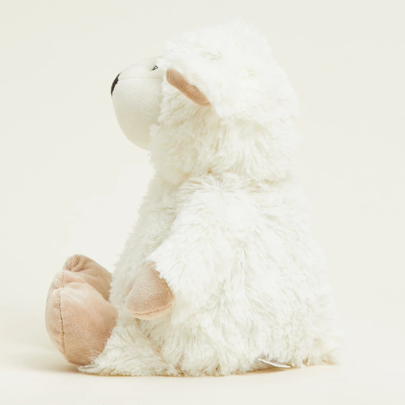 White plush toy sheep on a light beige background