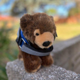 Grizzly Bear plushie wearing a blue emotional support vest - emotional support stuffed animal