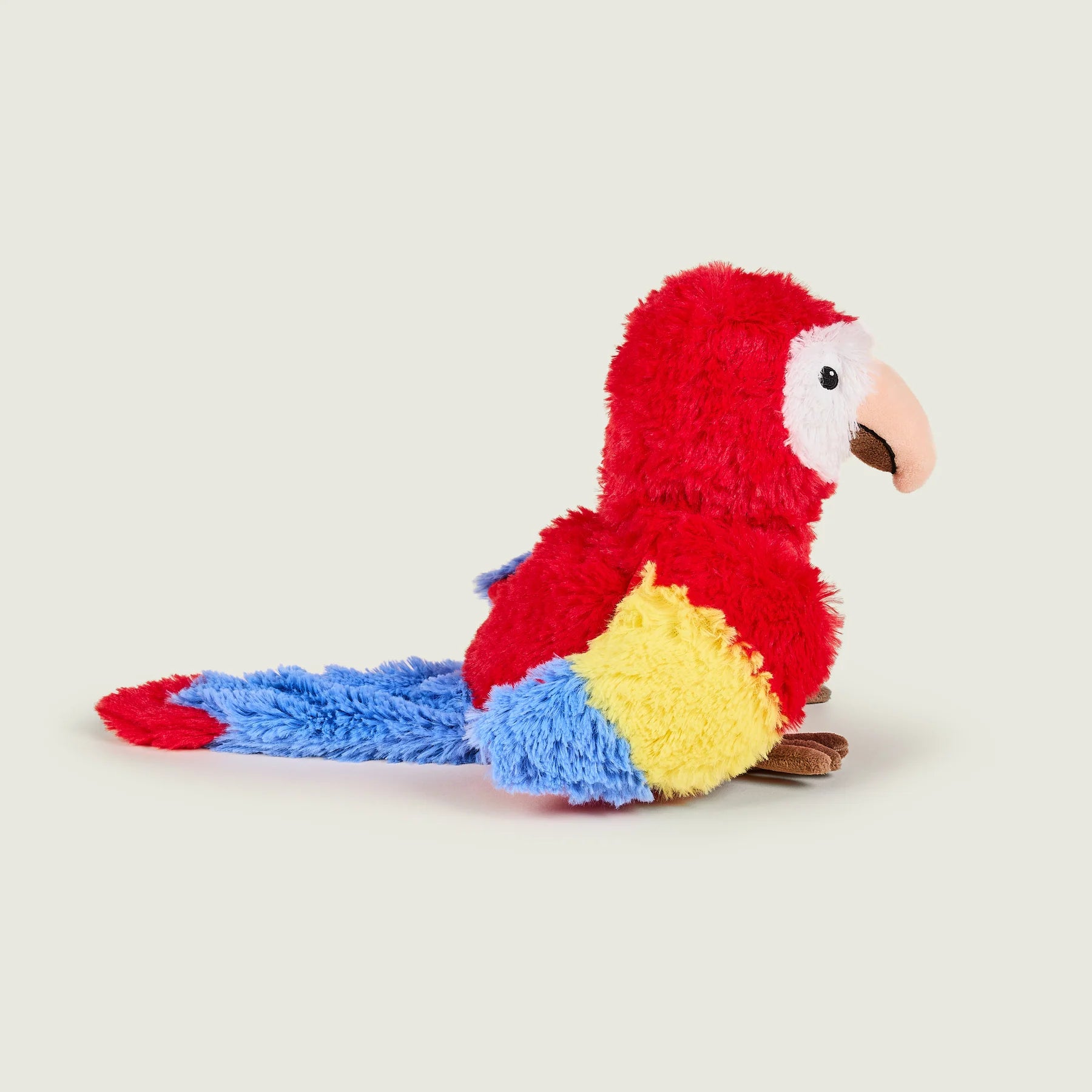 Colorful plush parrot toy on a light beige background