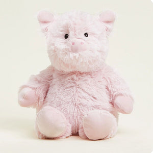 A soft pink plush pig toy with a fluffy texture, black bead eyes, and a pink snout, sitting against a light cream background.