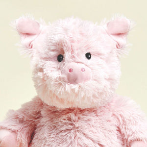 Close-up of a pink plush pig toy with a soft focus background